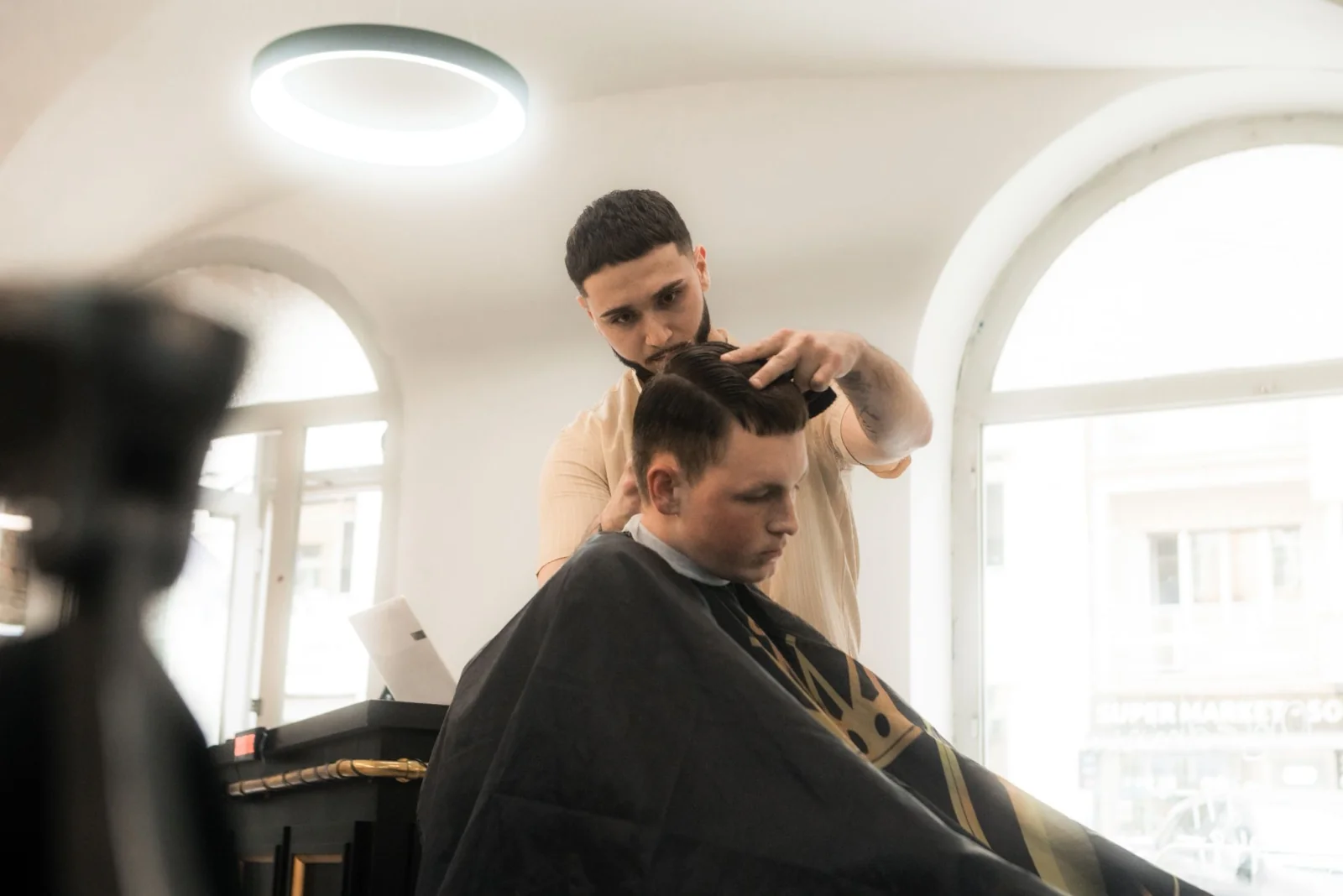 Barber Elite Barbershopu při stylingu vlasů, klenutý strop s designovými lampami a arched windows na Štěpánské