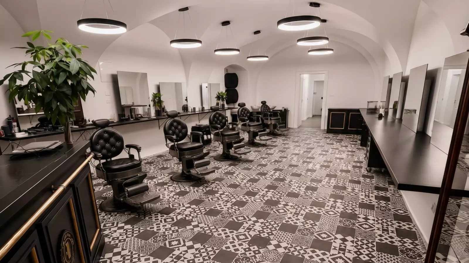 Interiér Elite Barbershopu, kožené židle, klenutý strop, cementové dlaždice